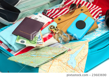 The open blue suitcase, sneakers, clothing, hat The open blue suitcase, sneakers, clothing, hat 23683690