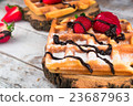 Belgium waffles with strawberries and chocolate.  23687963