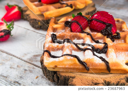 Belgium waffles with strawberries and chocolate.  23687963