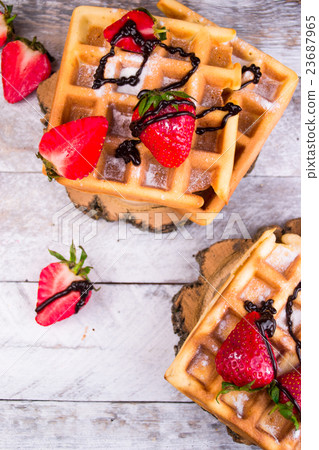 Belgium waffles with strawberries and chocolate.  23687965