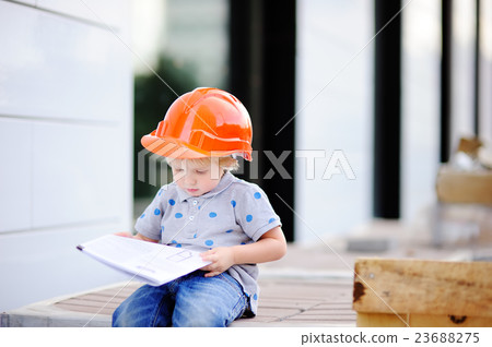 Little builder in hardhats with construction drawing Little builder in hardhats with construction drawing 23688275