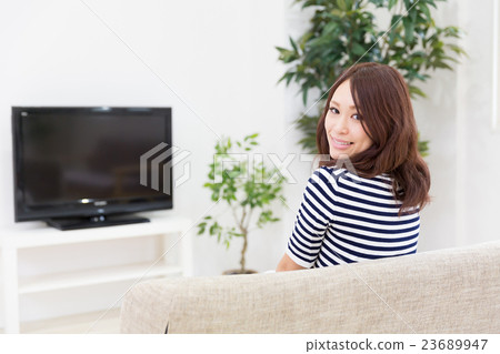A woman watching TV A woman watching TV 23689947