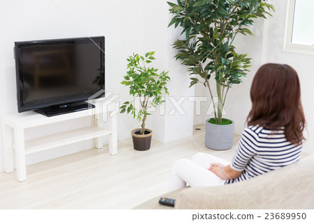 A woman watching TV A woman watching TV 23689950