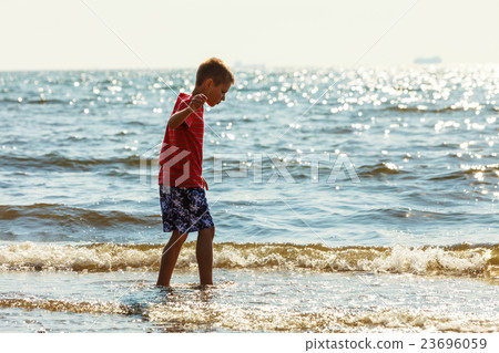 Boy walking on beach. Boy walking on beach. 23696059