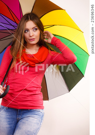Woman standing under multicolored umbrella Woman standing under multicolored umbrella 23696346