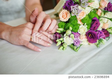Bride hand with gold ring a wedding bouquet on 23696894
