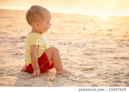 Kid sitting on beach 23697829