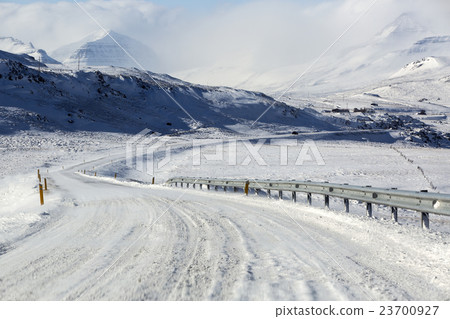 Snowy and icy road with volcanic mountains Snowy and icy road with volcanic mountains 23700927