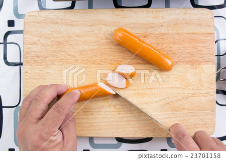 Chef cutting sausage on the wooden board 23701158