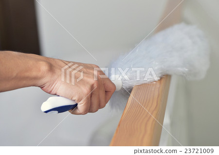 Stock Photo: young man dusting the house with a duster