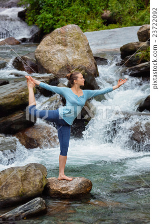 Woman doing yoga asana Natarajasana outdoors at Woman doing yoga asana Natarajasana outdoors at 23722092