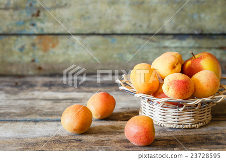 Ripe apricots in white bowl on wooden background Ripe apricots in white bowl on wooden background 23728595