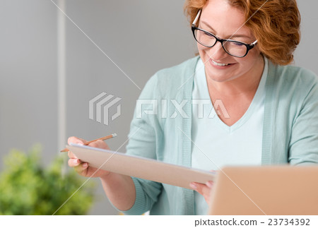 Cheerful woman sitting at the table Cheerful woman sitting at the table 23734392