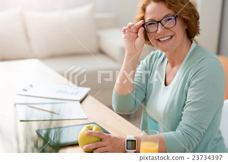 Cheerful woman sitting at the table 23734397