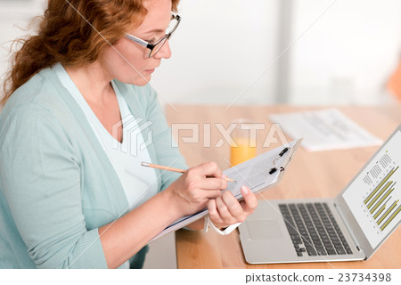 Concentrated woman using laptop Concentrated woman using laptop 23734398