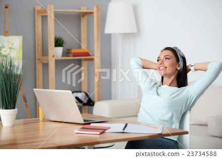 Positive delighted woman sitting at the table Positive delighted woman sitting at the table 23734588