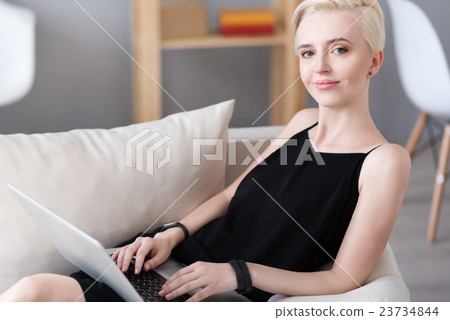 Woman sitting and using laptop Woman sitting and using laptop 23734844