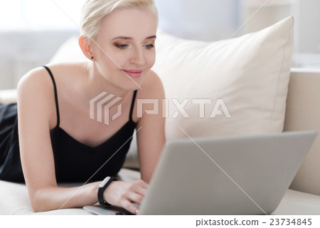 Woman relaxing on the bed with laptop Woman relaxing on the bed with laptop 23734845