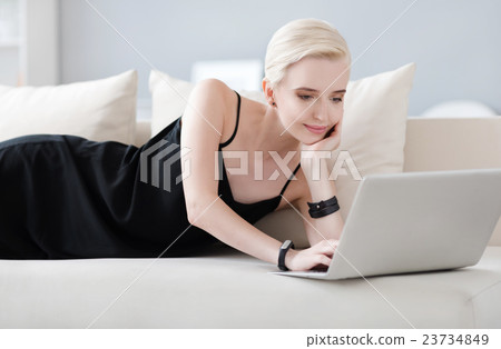 Woman lying on the bed with laptop Woman lying on the bed with laptop 23734849