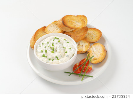 sliced toasted baguette and chives spread 23735534