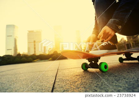 skateboarder tying shoelace at city skateboarder tying shoelace at city 23738924