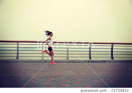 young fitness woman runner running on seaside road young fitness woman runner running on seaside road 23739932