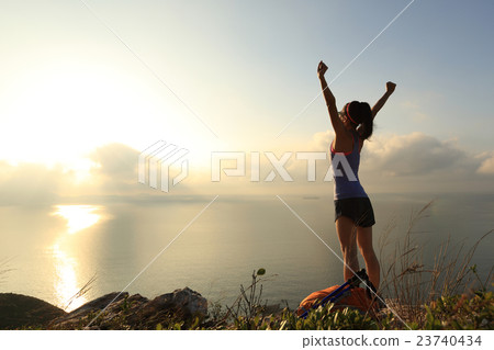 cheeringwoman backpacker at sunrise seaside cheeringwoman backpacker at sunrise seaside 23740434