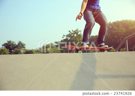 young skateboarder practice ollie at skatepark young skateboarder practice ollie at skatepark 23741926