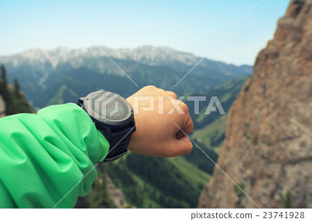 hiker checking the altimeter on sports watch hiker checking the altimeter on sports watch 23741928