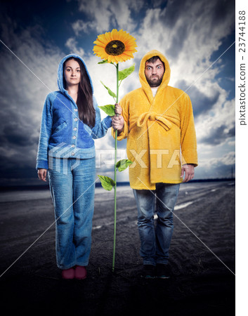 Strange couple holding sunflower Strange couple holding sunflower 23744188