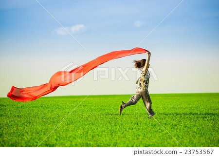 Beautiful young woman jumping on a green meadow 23753567
