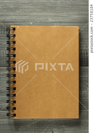 checked notebook on wooden table 23758184