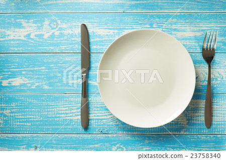 plate, knife and fork on rustic background 23758340