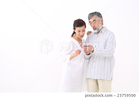 A couple looking at smartphones A couple looking at smartphones 23759500