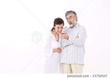 A couple looking at smartphones A couple looking at smartphones 23759507