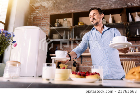 Man putting cups on the table Man putting cups on the table 23763668