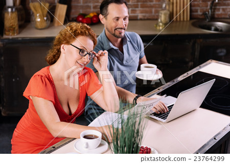 Surprised woman reading news in kitchen Surprised woman reading news in kitchen 23764299