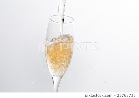 Pour the sparkling wine into the glass 23765735