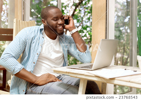 Positive smiling man talking on cell phone Positive smiling man talking on cell phone 23768543