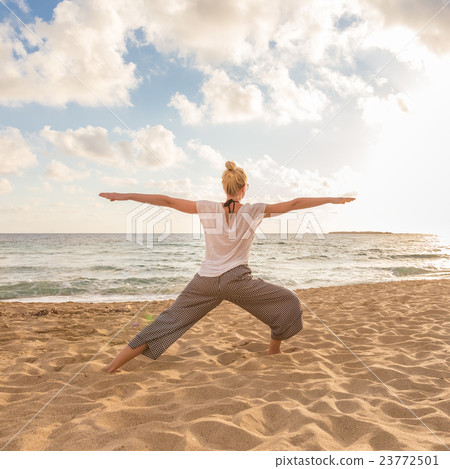 Woman practicing yoga on sea beach at sunset. 23772501