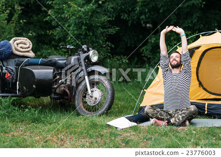 Happy man relaxing in forest on summer morning 23776003