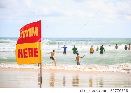 SWIM HERE red flag on the beach SWIM HERE red flag on the beach 23776758