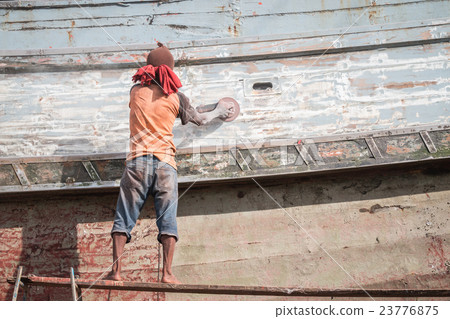 A man using grinder in preparation for anti foul paint being applied 23776875