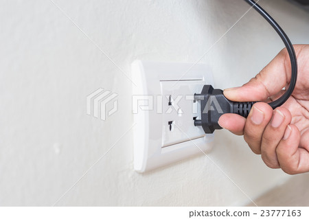 Unplug or plugged in concept,hand holding and pull electric plug 23777163