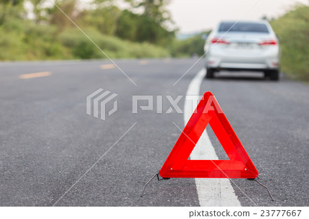 Red emergency stop sign and broken car on the road 23777667