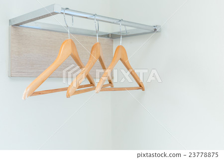 Wooden cloth hangers on the wall in hotel room 23778875