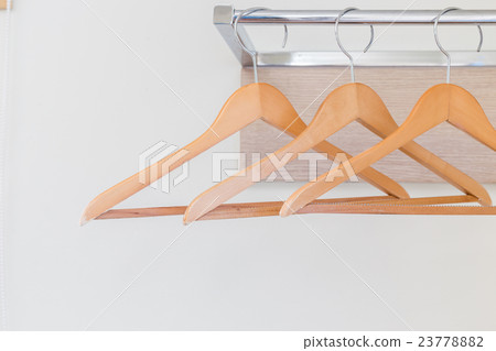 Wooden cloth hangers on the wall in hotel room 23778882