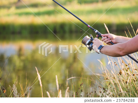 Man holding a fishing-rod. 23784288