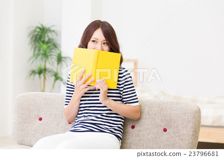 讀一本書的婦女在屋子裡 23796681