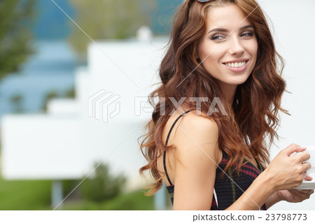 Woman drinking coffee in hotel terrace over sea Woman drinking coffee in hotel terrace over sea 23798773
